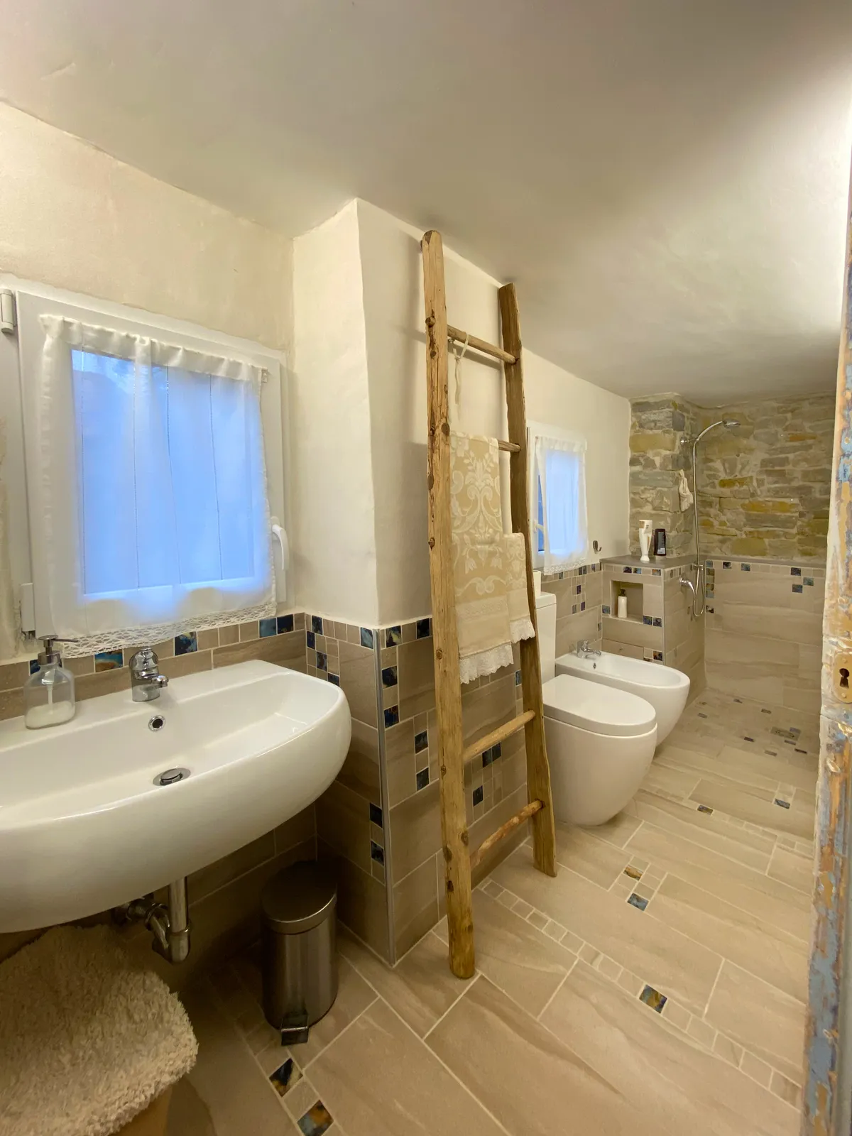 Bagno con doccia in pietra e finiture artigianali